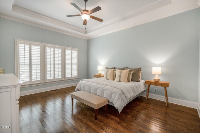 bedroom featuring a raised ceiling, crown molding, and wood finished floors