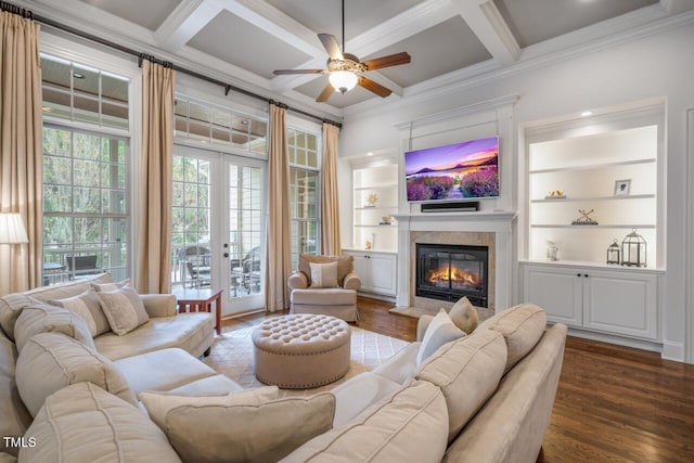 living room with a glass covered fireplace, dark wood-type flooring, coffered ceiling, and ornamental molding