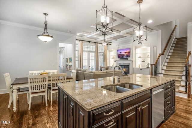 kitchen featuring dark wood finished floors, dishwasher, a glass covered fireplace, coffered ceiling, and a sink