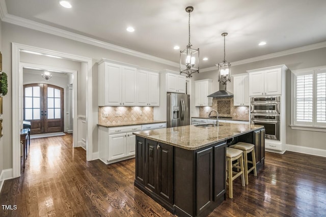 kitchen with a sink, french doors, arched walkways, stainless steel appliances, and dark wood-style flooring