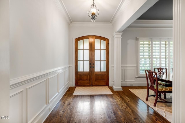 entrance foyer featuring french doors, wood finished floors, arched walkways, a decorative wall, and ornate columns