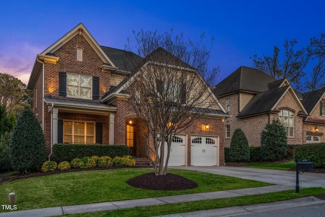 view of front of property featuring a garage, brick siding, driveway, and a lawn