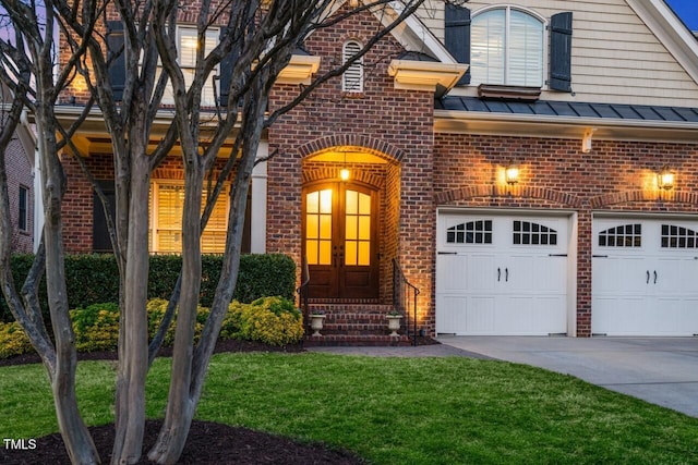 view of front of home featuring french doors, brick siding, and a standing seam roof