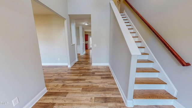 stairway featuring baseboards and wood finished floors