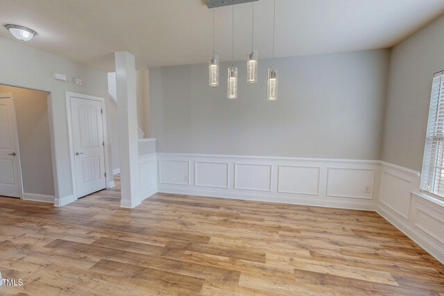 spare room featuring a decorative wall and light wood-type flooring