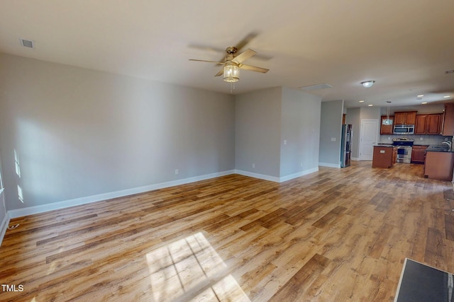 unfurnished living room with light wood-type flooring, visible vents, a ceiling fan, recessed lighting, and baseboards