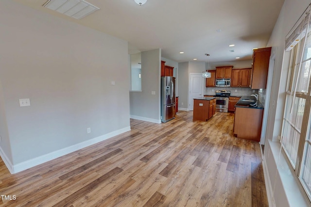 kitchen with visible vents, backsplash, dark countertops, stainless steel appliances, and baseboards