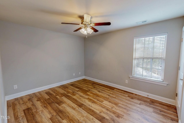 unfurnished room featuring visible vents, a ceiling fan, baseboards, and wood finished floors