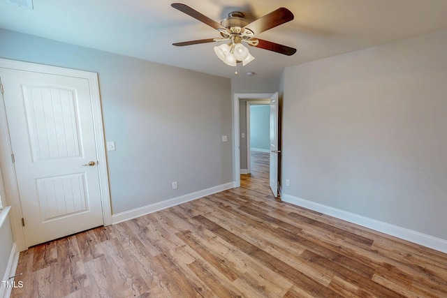 empty room featuring ceiling fan, light wood-type flooring, and baseboards