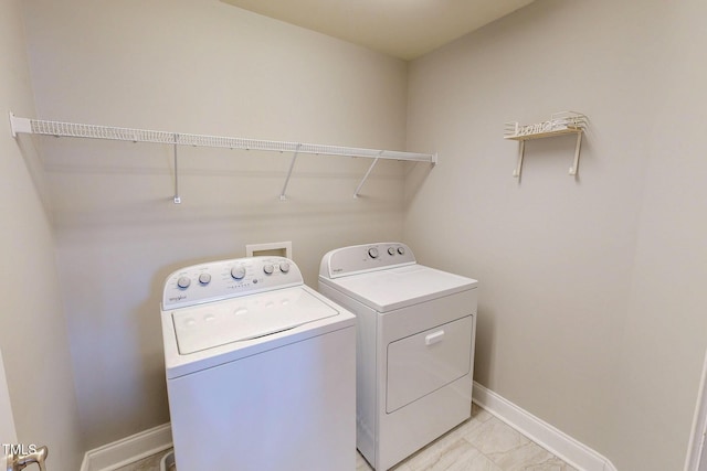 laundry room featuring baseboards, laundry area, and washer and clothes dryer