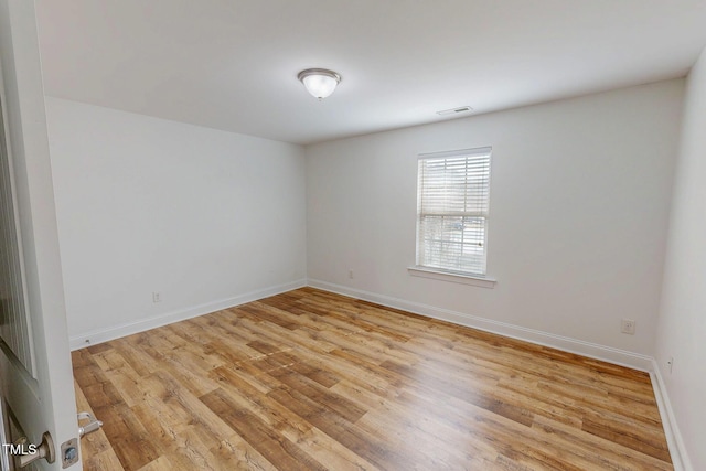 spare room featuring visible vents, baseboards, and light wood-style floors