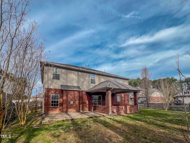 rear view of house with a yard, a fenced backyard, brick siding, and a patio