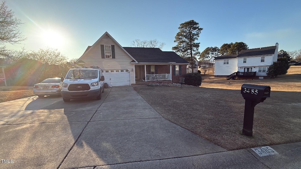 view of front facade featuring covered porch, driveway, and an attached garage