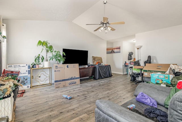 living area with baseboards, lofted ceiling, a ceiling fan, and wood finished floors