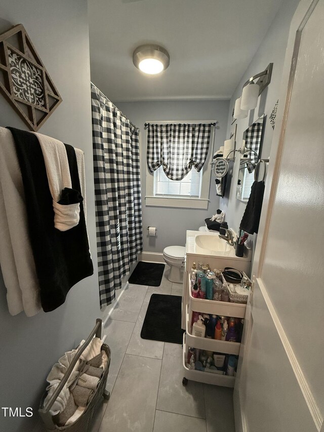 bathroom with curtained shower, toilet, vanity, and tile patterned flooring