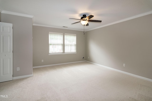 empty room featuring ceiling fan, light colored carpet, ornamental molding, and baseboards
