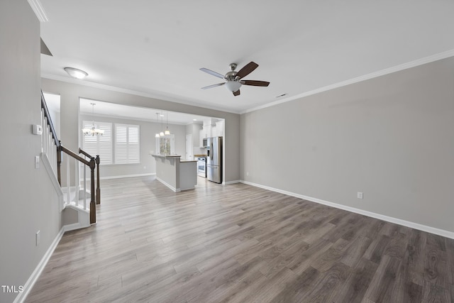 unfurnished living room with stairway, baseboards, light wood-style flooring, crown molding, and ceiling fan with notable chandelier