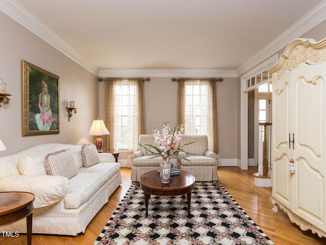 living area with light wood-style flooring, baseboards, and ornamental molding