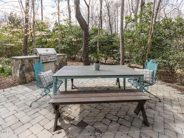 view of patio / terrace with outdoor dining space, an outdoor kitchen, and a grill