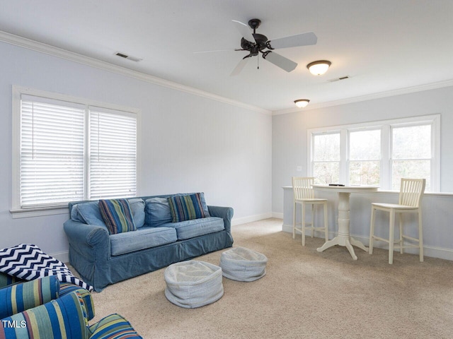 living area featuring visible vents, baseboards, carpet, and ornamental molding