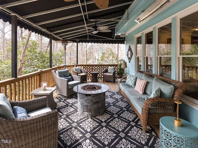 wooden deck with an outdoor living space with a fire pit and a ceiling fan