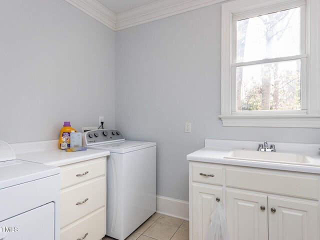 laundry room with crown molding, washing machine and dryer, light tile patterned flooring, cabinet space, and a sink