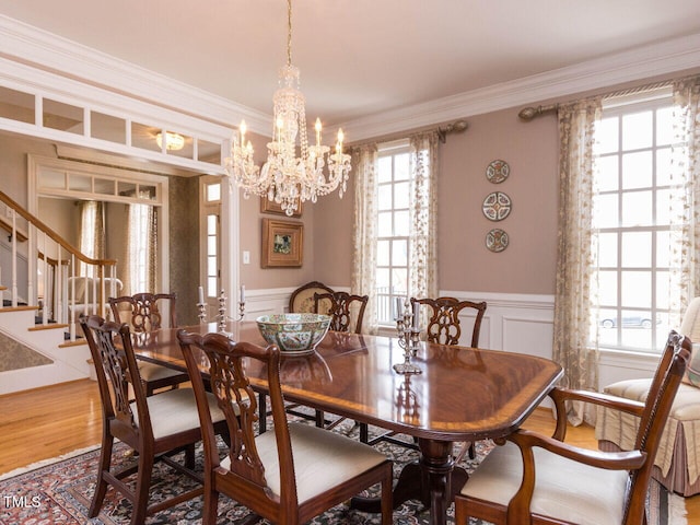 dining room with wainscoting, stairs, ornamental molding, and wood finished floors