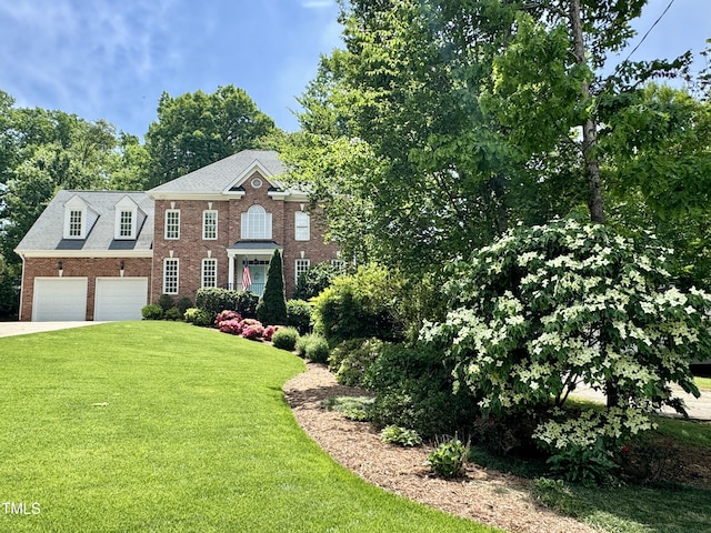 view of front of house with brick siding, a front yard, and concrete driveway