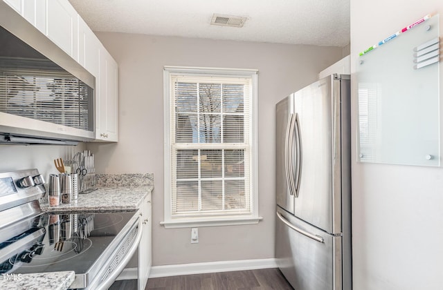 kitchen with visible vents, white cabinets, appliances with stainless steel finishes, and a textured ceiling