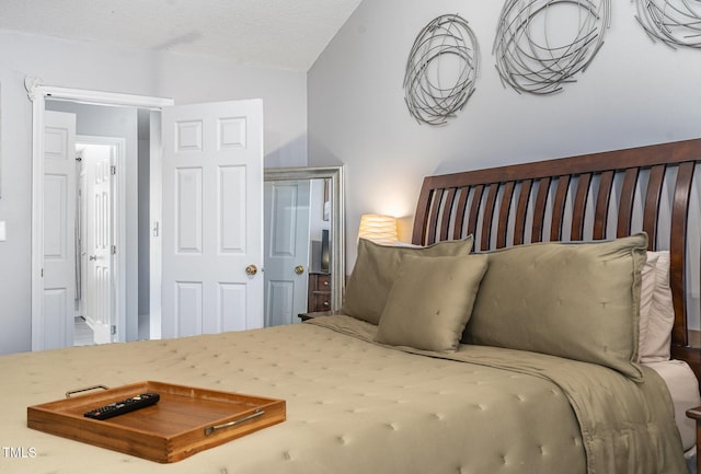 bedroom with a textured ceiling and vaulted ceiling