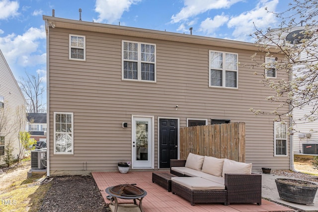 back of house featuring a wooden deck, central AC, an outdoor living space with a fire pit, and fence