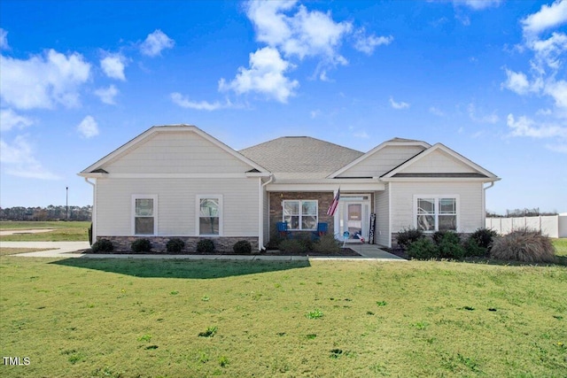 view of front of property with a front lawn and stone siding