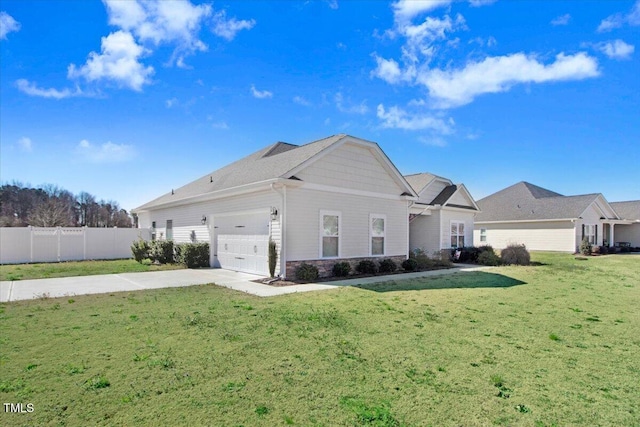 view of side of property featuring fence, driveway, a yard, stone siding, and a garage