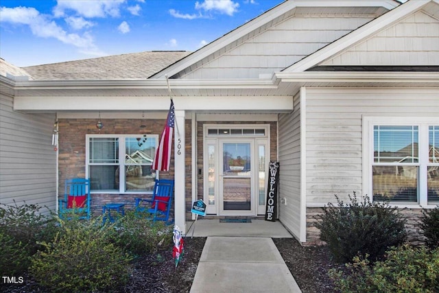 property entrance with roof with shingles and covered porch