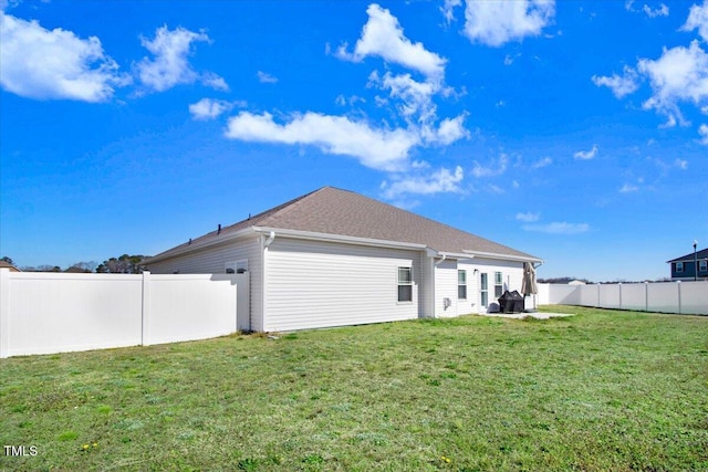 back of house featuring a yard and a fenced backyard