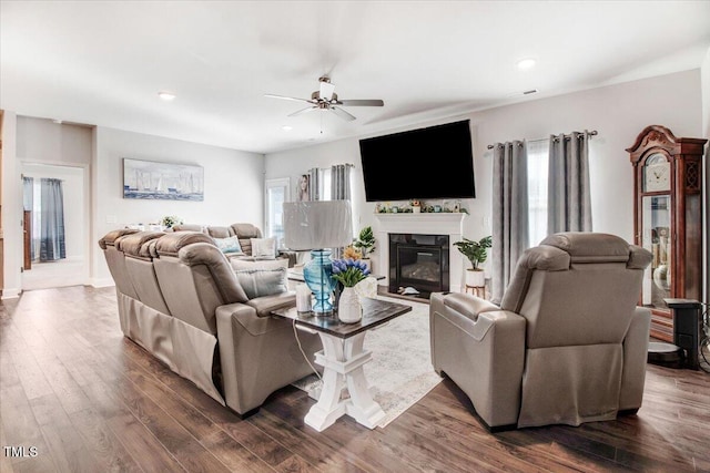 living area with a glass covered fireplace, recessed lighting, dark wood-style floors, and ceiling fan