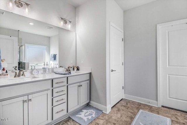 full bathroom featuring double vanity, visible vents, baseboards, and a sink