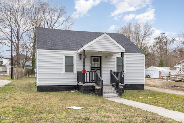 bungalow-style home featuring a front lawn and roof with shingles