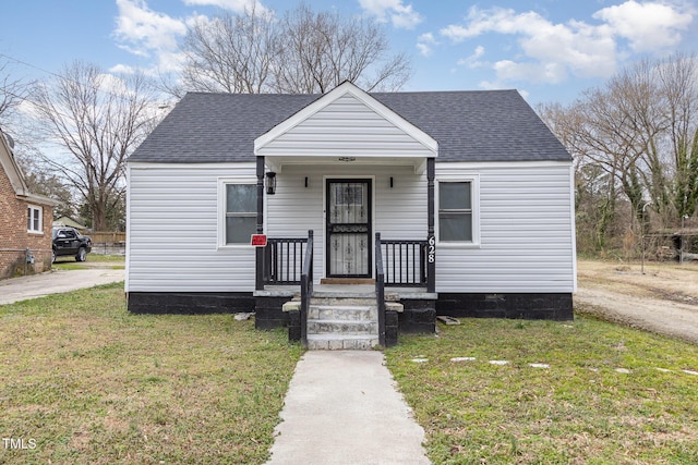 bungalow featuring roof with shingles and a front lawn