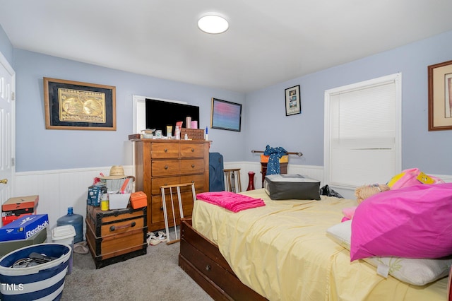 carpeted bedroom featuring a wainscoted wall