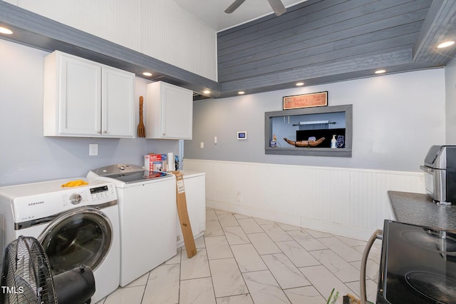 laundry area featuring wainscoting, cabinet space, marble finish floor, a ceiling fan, and separate washer and dryer