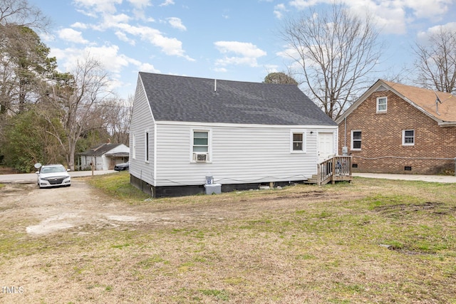 back of house with a yard and a shingled roof