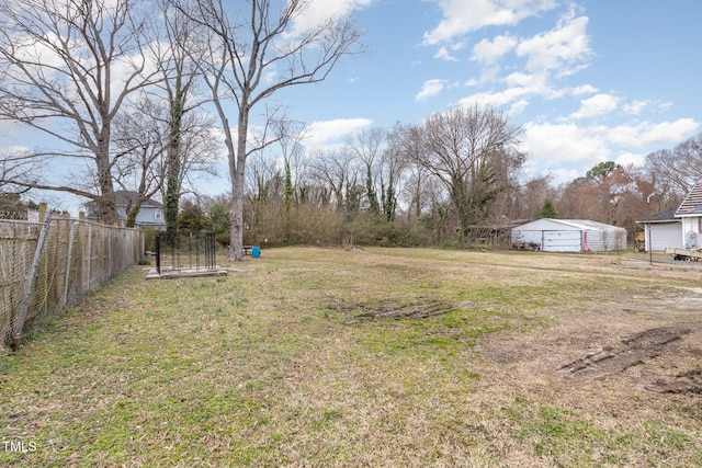 view of yard featuring fence and a garage