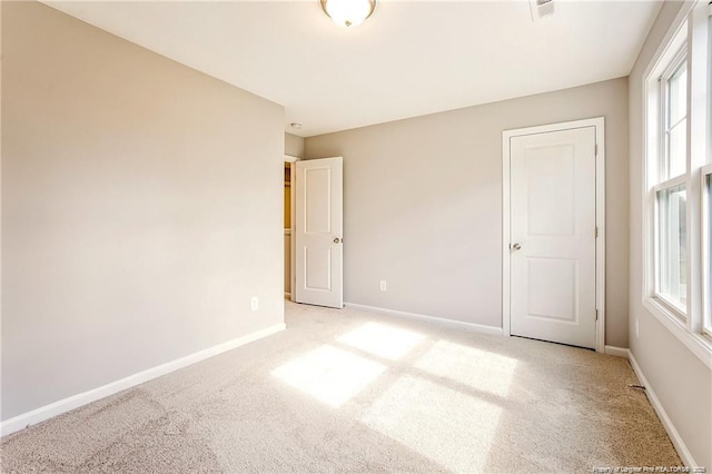 empty room with light carpet and baseboards