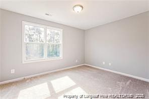 empty room featuring carpet flooring and baseboards