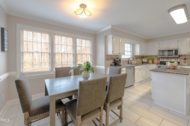 dining space featuring baseboards and crown molding