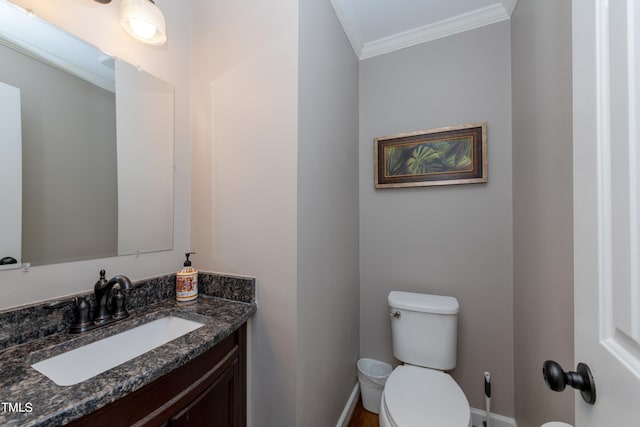 half bath featuring baseboards, vanity, toilet, and crown molding