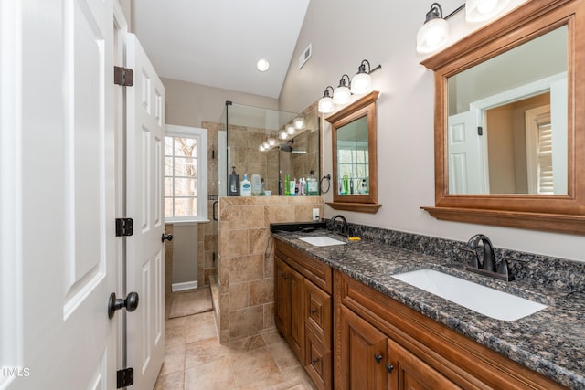 bathroom featuring double vanity, tiled shower, visible vents, and a sink