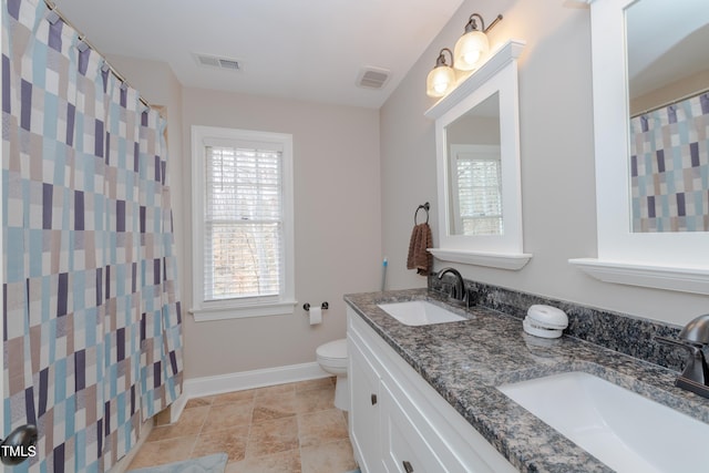 bathroom featuring visible vents, toilet, baseboards, and a sink