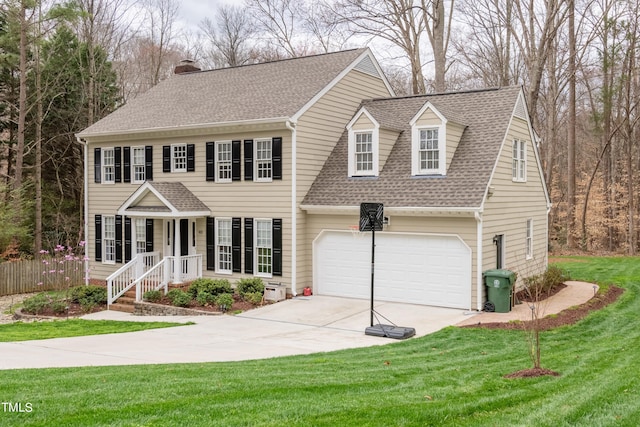 colonial home with a front lawn, concrete driveway, a shingled roof, a garage, and a chimney